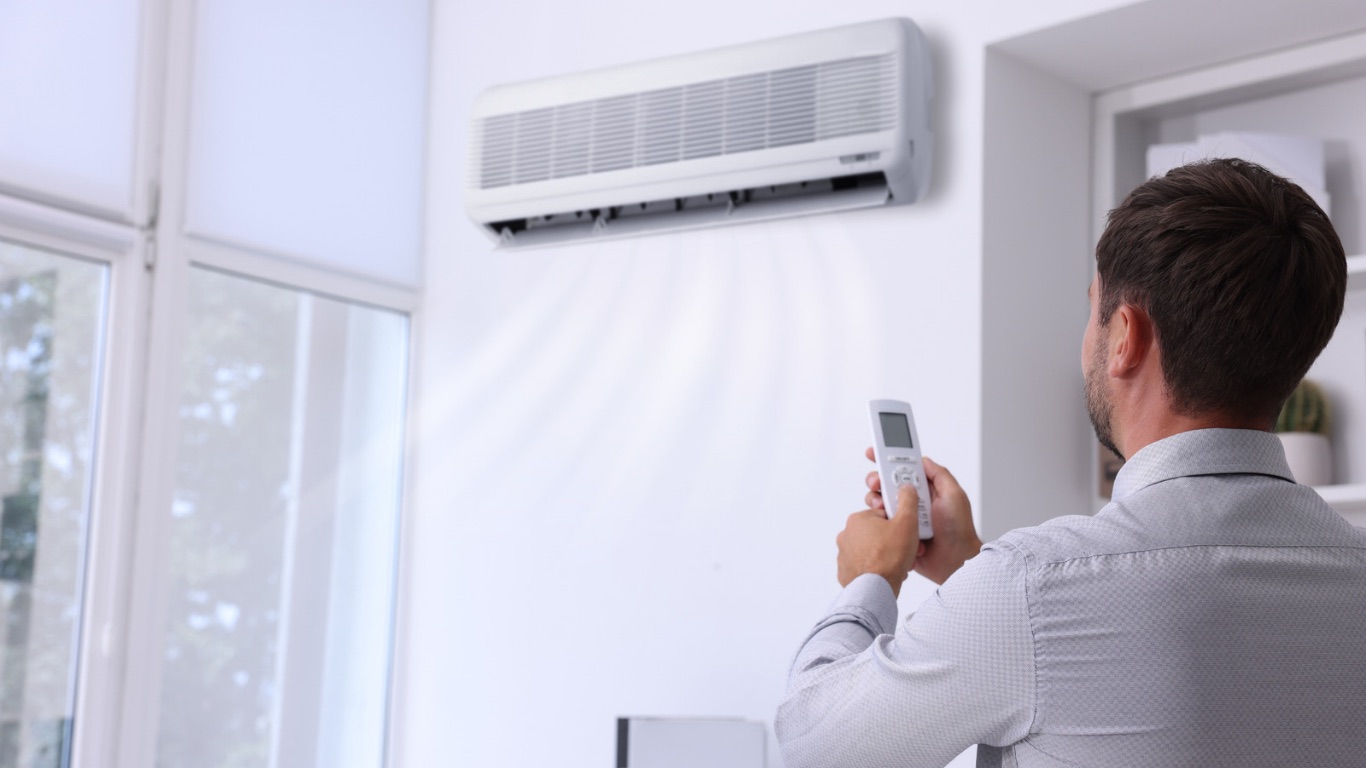Person cooling a Brisbane living room with a wall mounted split system air conditioner